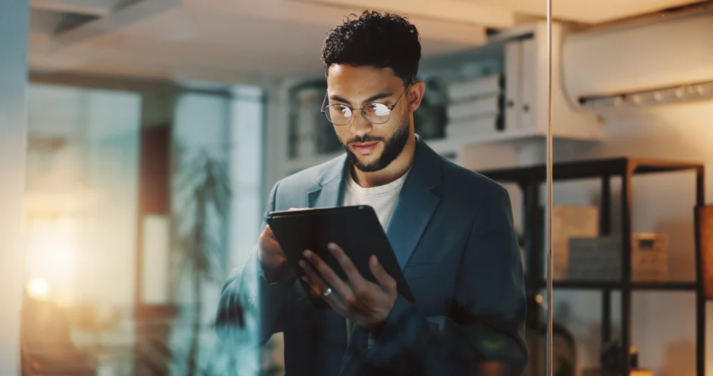 Social media manager en train de travailler sur sa tablette pour optimiser les réseaux sociaux de ses clients.