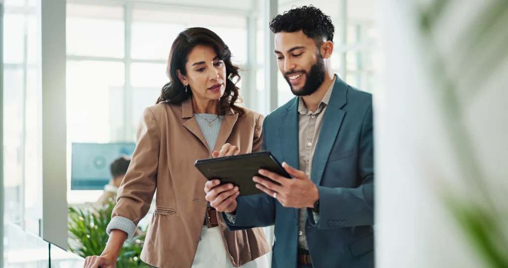 Réunion d'équipe autour d'une tablette affichant des données numériques, illustrant l'importance d'un site internet comme outil stratégique pour piloter la croissance d'une entreprise.