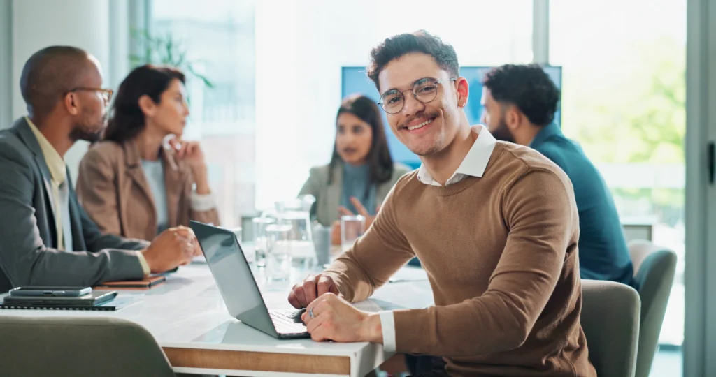 un webdesigner souriant en réunion de travail autour de l'importance d'avoir un site internet bien conçu