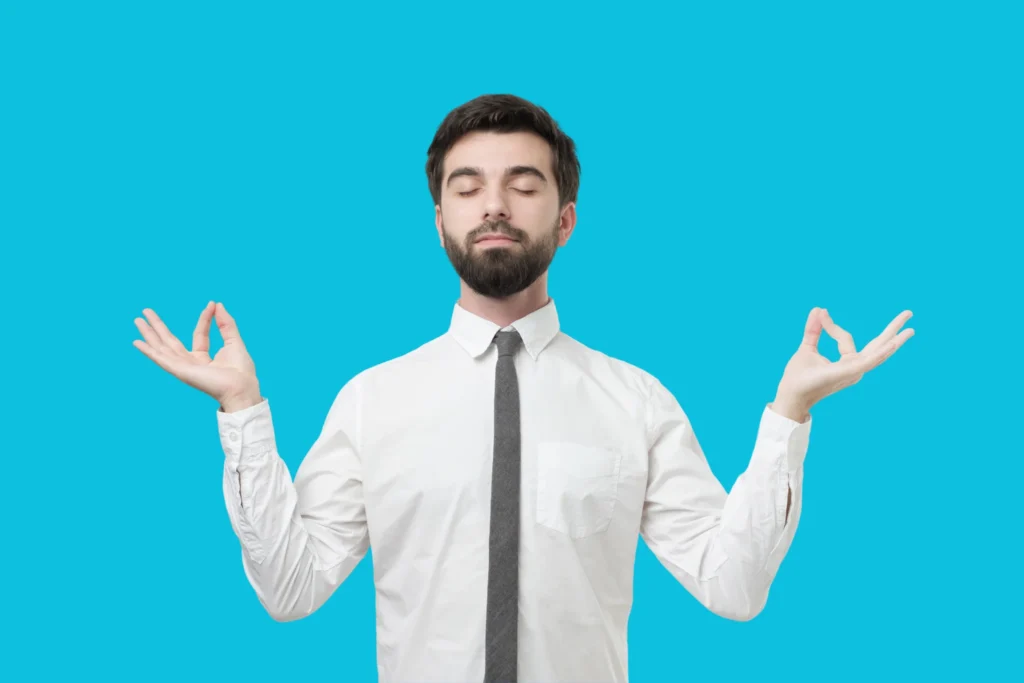 Image d'un chef d'entreprise de TPE/PME en train de fermer les yeux et de faire les signes mudra avec ses mains, pour montrer qu'en externalisation sa communication il peut être plus zen et détendu.