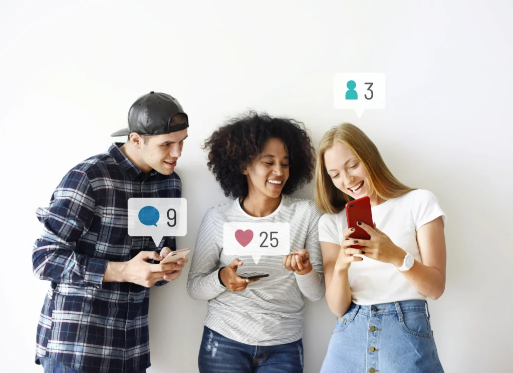 Trois personnes souriantes sur smartphones avec notifications d'engagement réseaux sociaux : likes, commentaires, partages