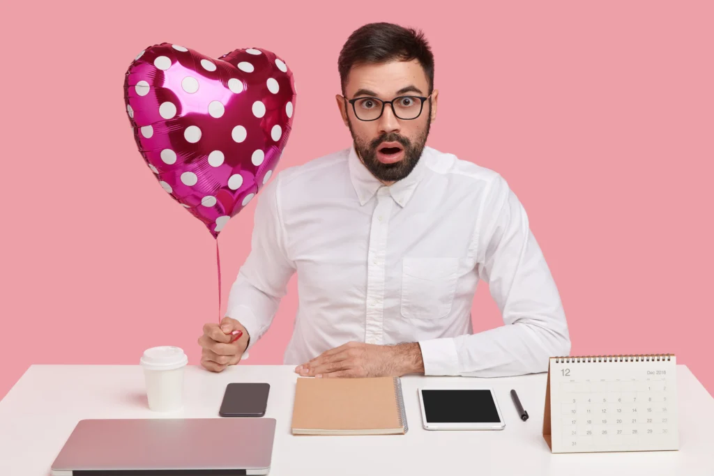 chef entreprise derrière son bureau avec un ballon en forme de coeur à la main pour illustrer l'histoire d'amour entre le SEO (référencement naturel) et le contenu